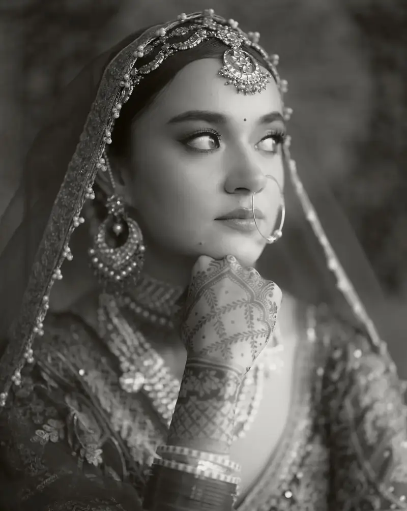 Black and white close-up of a bride with her chin resting on her hand