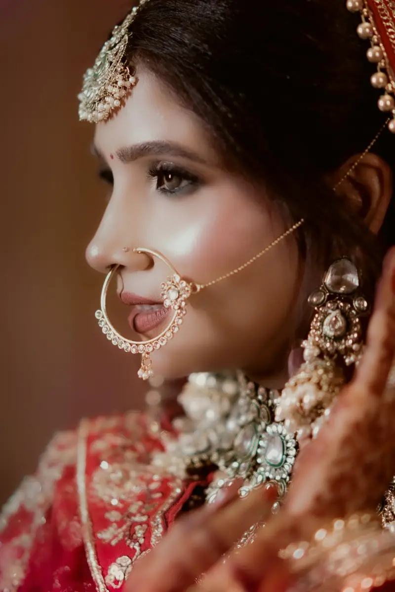 Side profile of a bride wearing a large nath and heavy earrings