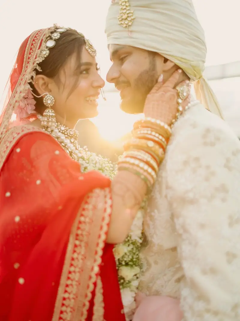 The bride holding the groom's face in the afternoon sun
