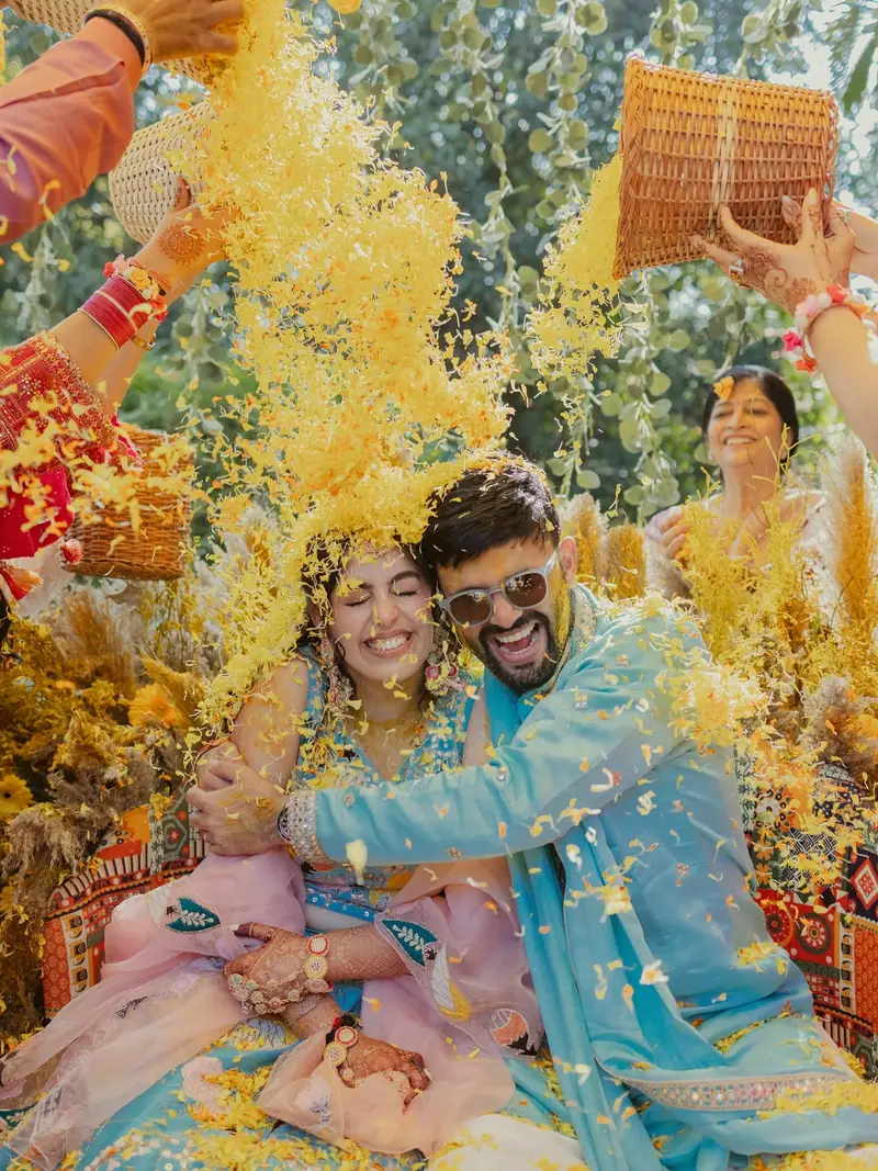 Relatives tipping baskets of yellow flowers over the couple