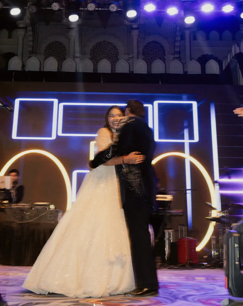 The couple dancing on a stage lit with neon arches and spotlights