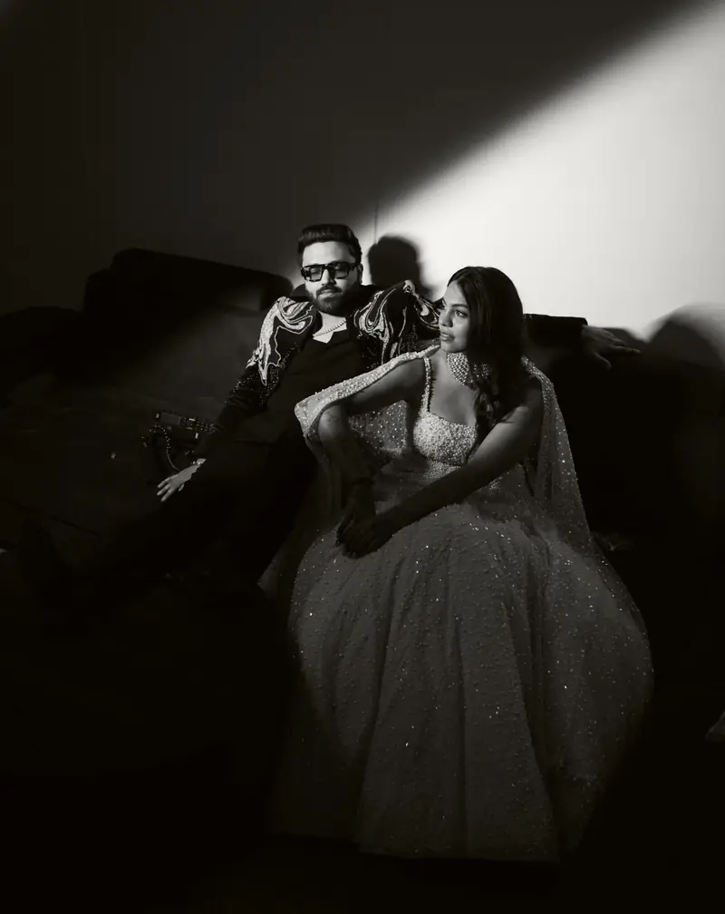 Black and white photo of the couple sitting together under a single beam of light