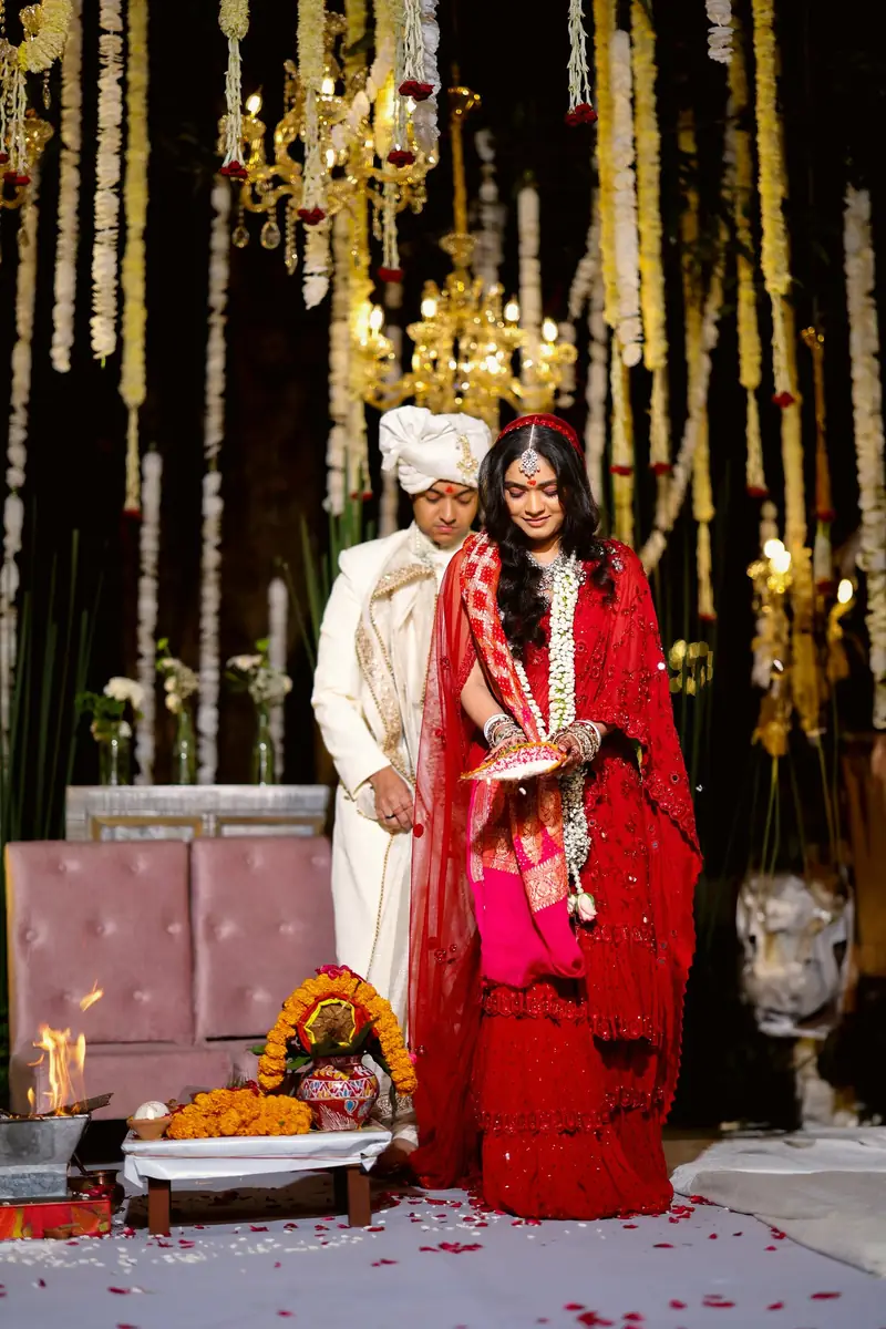 The bride and groom standing at the mandap beside the sacred fire
